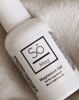 A small white bottle of Só Magnesium Gel placed on a beige fabric.