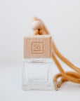 Small square glass jar with a Só branded wooden lid and wood bead with tan coloured shoelace-like string
