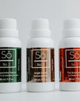 Three bottles of Só No 2 Toilet Drops on a white background labelled Peppermint Patties, Jingle Smells and The Buttcracker