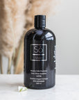 A 500 ml black bottle of 'So Silver' Mission Falls Premium Ionic Silver Solution, standing on a white marble surface with dried pampas grass in the background.