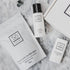 Só Dry Hands Bundle products arranged on a light marble surface, including a small Coconut & Oat Milk Bath packet, a bottle of Peppermint hand sanitizer, an All Purpose Salve tube, and part of a white box.