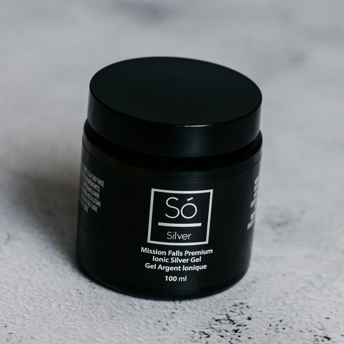 A black jar of Só Silver Mission Falls Premium Ionic Silver Gel, 100 ml, set on a textured light gray surface.